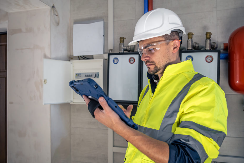 electrical-technician-looking-focused-while-working-switchboard-with-fuses.jpg